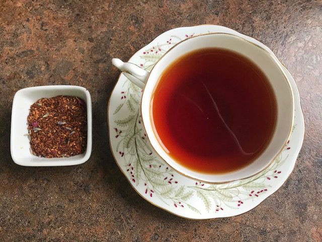 Provence Rooibos brewed in cup with loose leaf in small dish.  Ready for smelling prior to tasting.