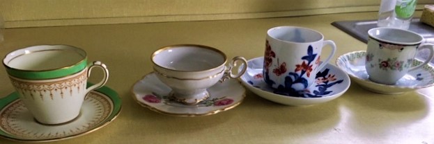 Line up of small vintage teacups to be used by guests at Cocoa Tea Party