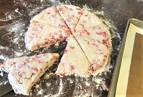 Strawberry cream scones patted into 7-8 inch circle, cut and ready to be placed on baking sheet