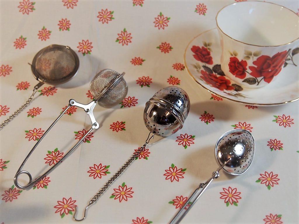 Single cup tea infusers lined up for display.
